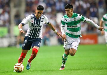 Maximiliano Meza (L) of Monterrey vies for the ball with Omar Campos (R) of Santos.